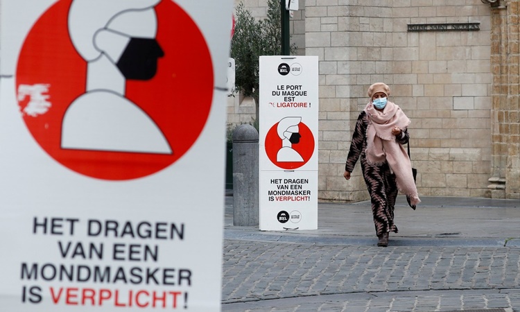 Biển báo yêu cầu người dân bắt buộc đeo khẩu trang trên đường phố thủ đô Brussels, Bỉ, ngày 16/10. Ảnh: Reuters.
