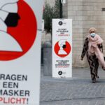 Biển báo yêu cầu người dân bắt buộc đeo khẩu trang trên đường phố thủ đô Brussels, Bỉ, ngày 16/10. Ảnh: Reuters.