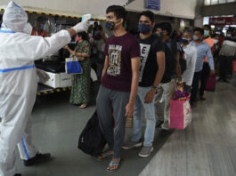Kiểm tra thân nhiệt tại ga tàu ở Mumbai, Ấn Độ, hôm 19/12. Ảnh: AFP.